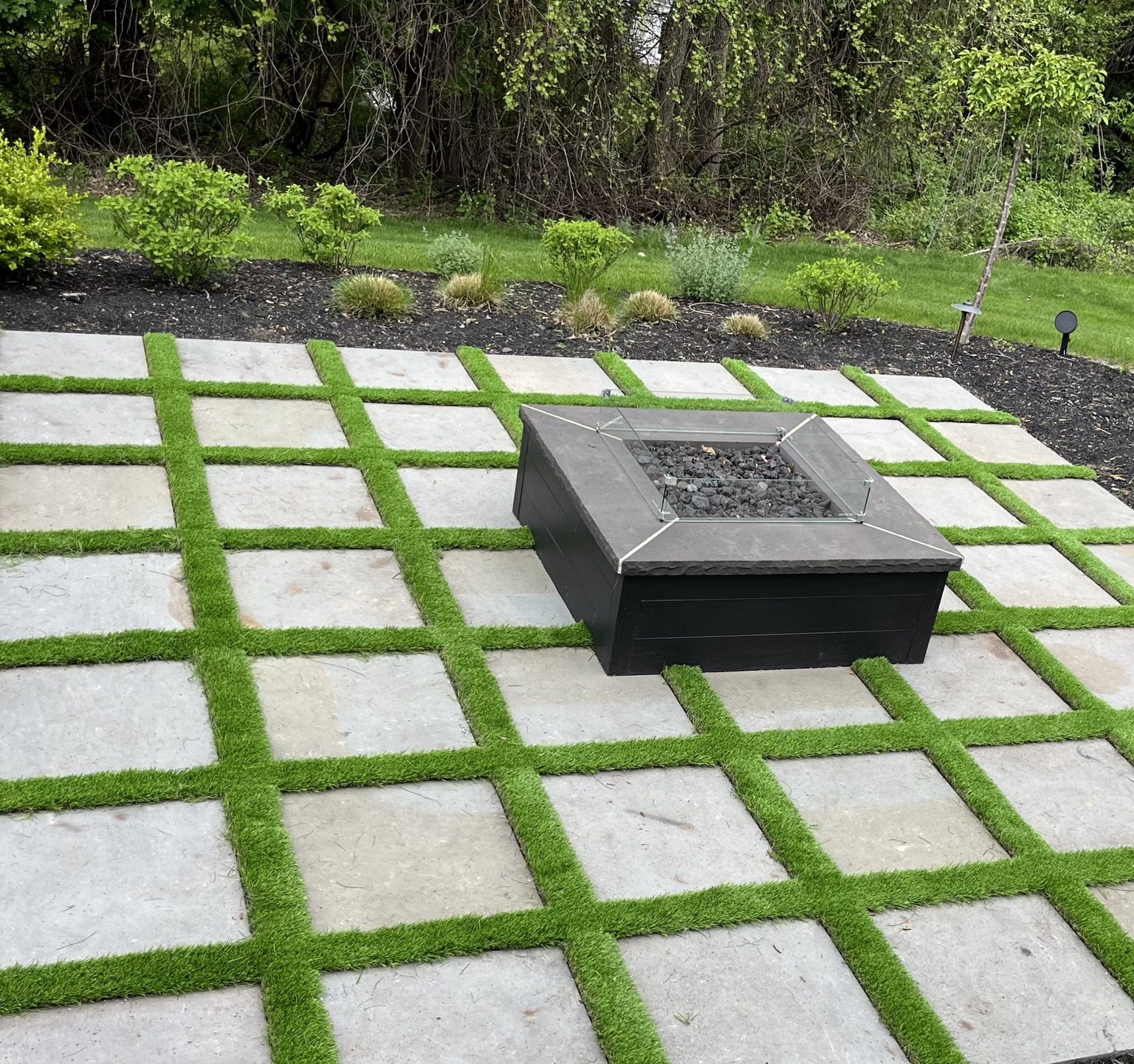 Modern grid patio with lawn joints and central fire pit